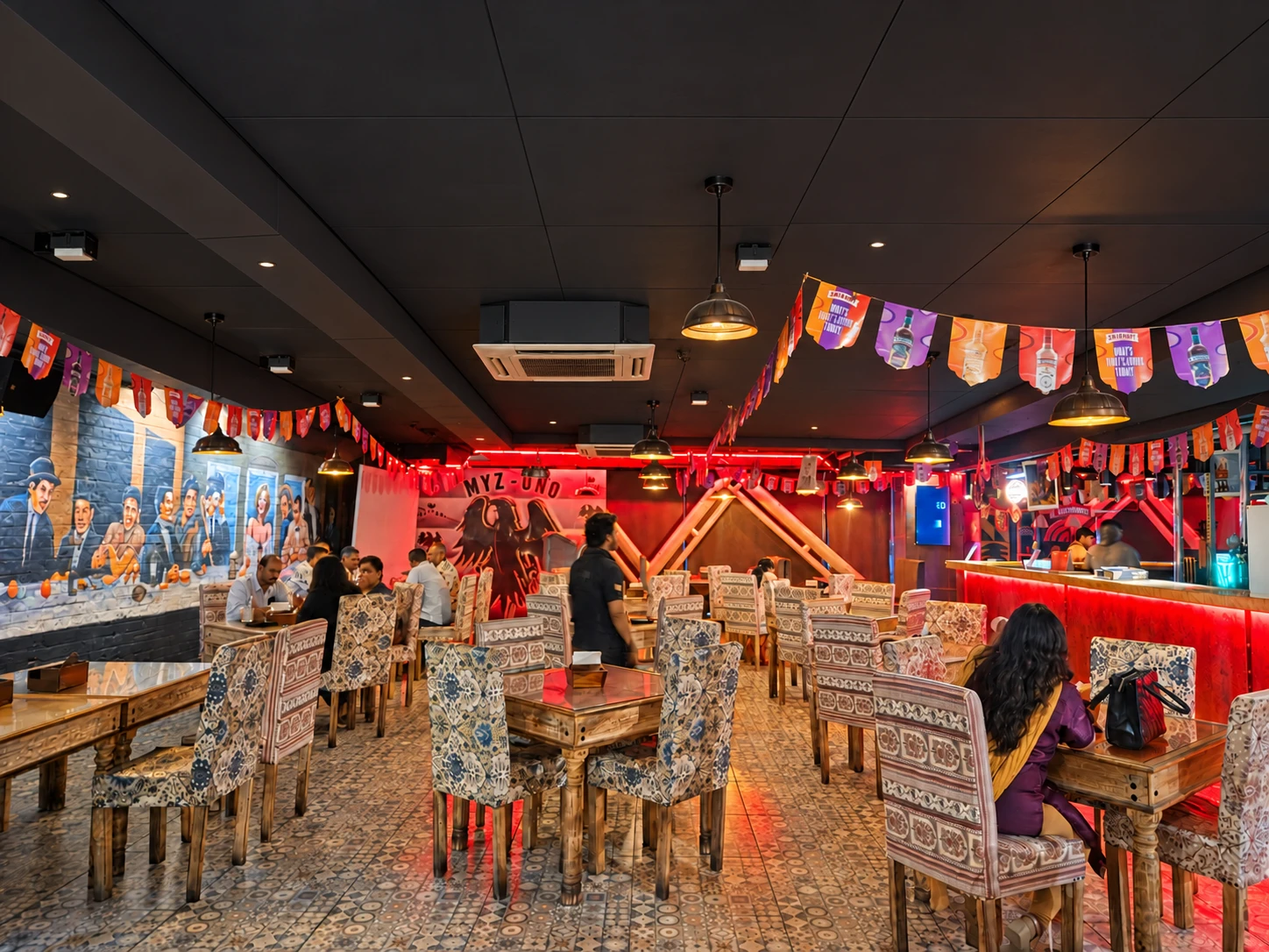 The dining room, warm lights and signature wall murals.